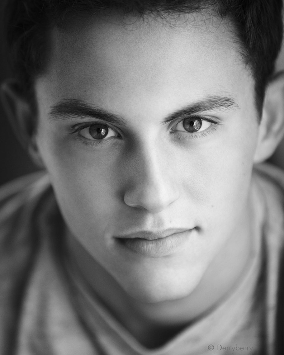 Close  up  black and white head shot senior portrait of former Greenhill student Daniel Matyas in the studio  in Dallas, Texas by photographer John Derryberry Photography