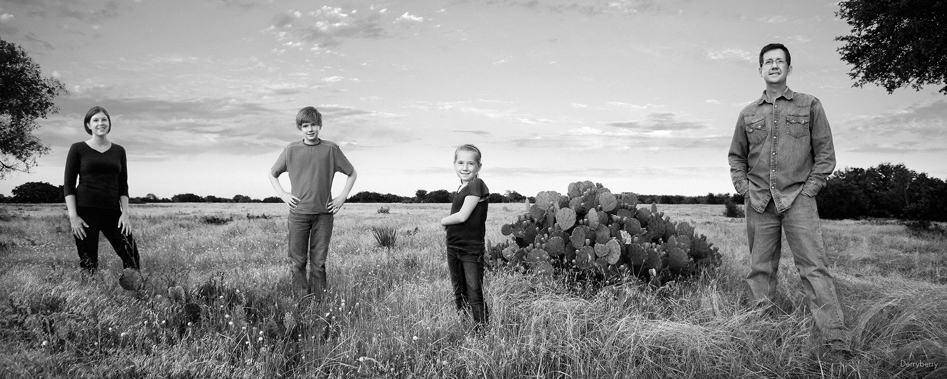 Black and white panoramic group portrait  of the Henderson family on their  ranch in West Texas by photographer John Derryberry Photography 