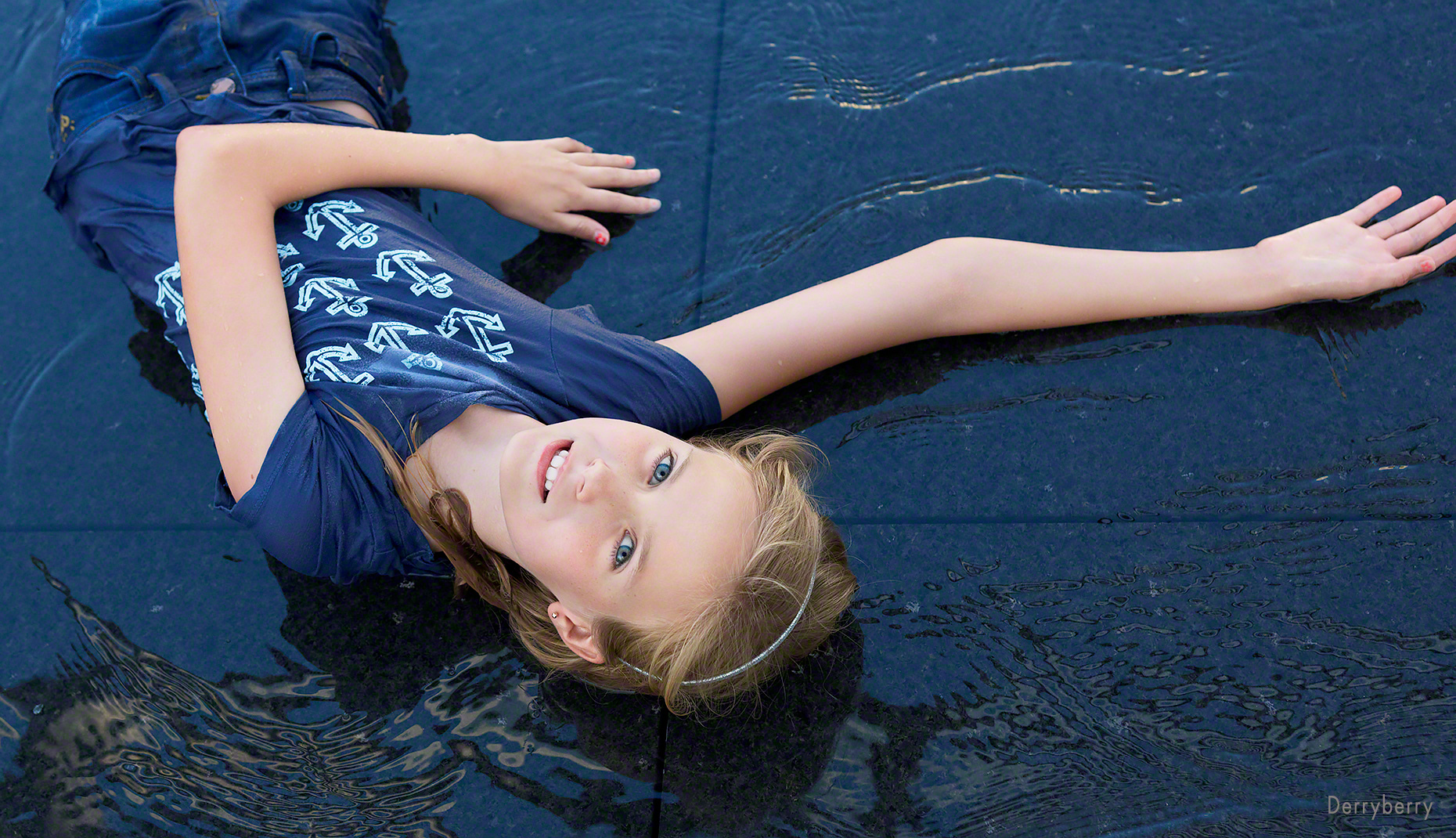Cool portrait of teen girl, Katherine Hancock laying in water in downtown Dallas, Texas by photographer, John Derryberry Photography