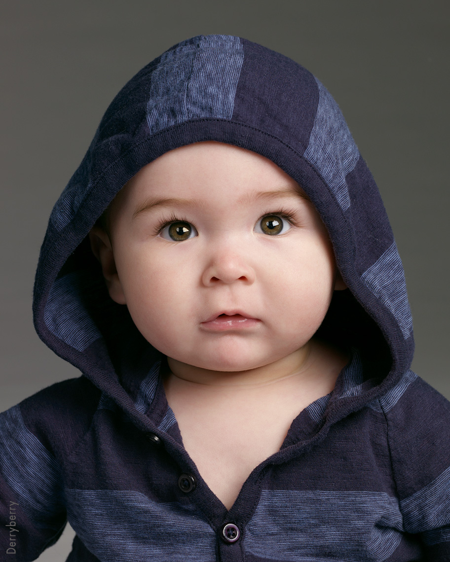 Portrait of a baby boy named Doc with a stripped blue hoody on.