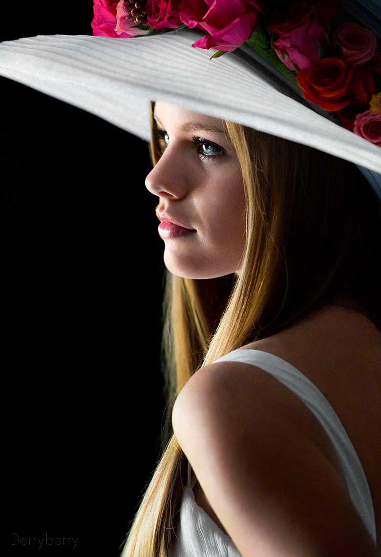 Color graduation day profile senior portrait  of Avery Hall  in flowered hat from Hockaday School in the studio  in Dallas, Texas by photographer John Derryberry Photography