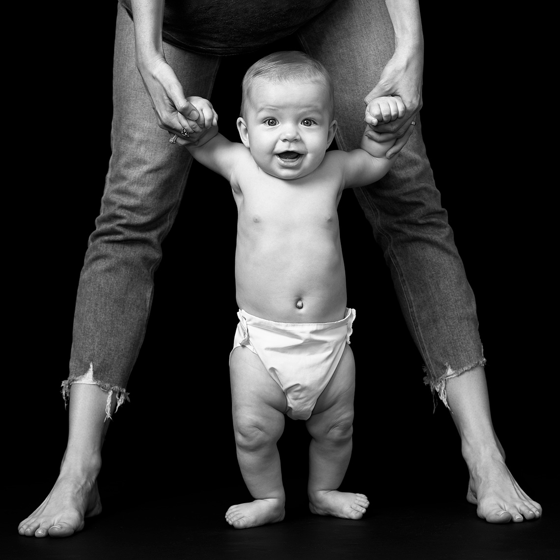 Portrait in black and white of baby boy  standing with mom