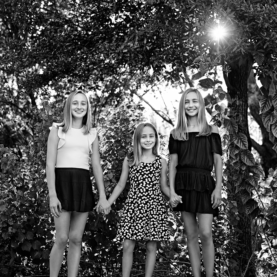 Black and white portrait of the Rhodes sister, Emory, Clary, Ellis  in a garden in Dallas, Texas by photographer John Derryberry Photography for the Crystal Charity Children