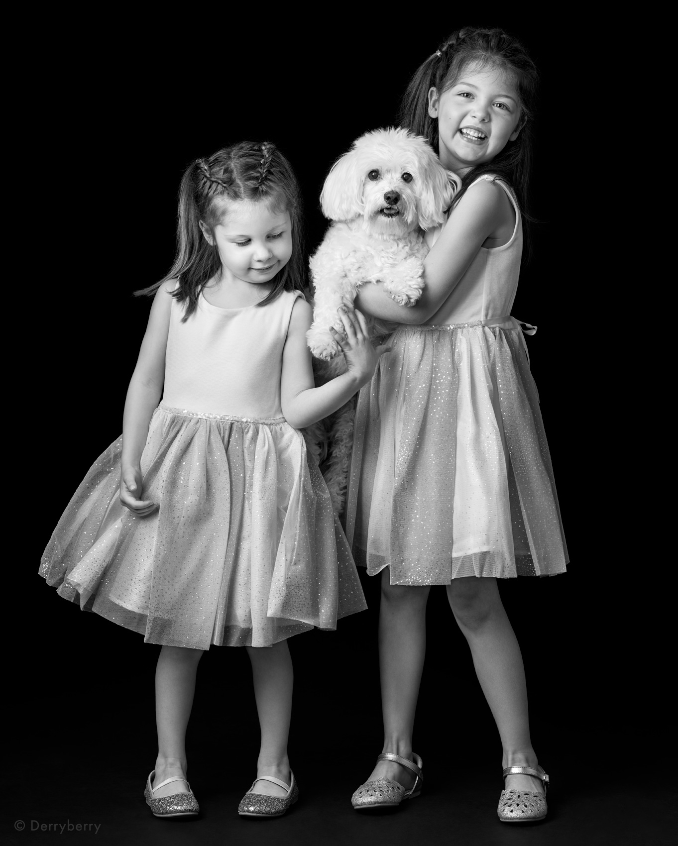  B&W full-length portrait of two young girls with sweet family dog in studio