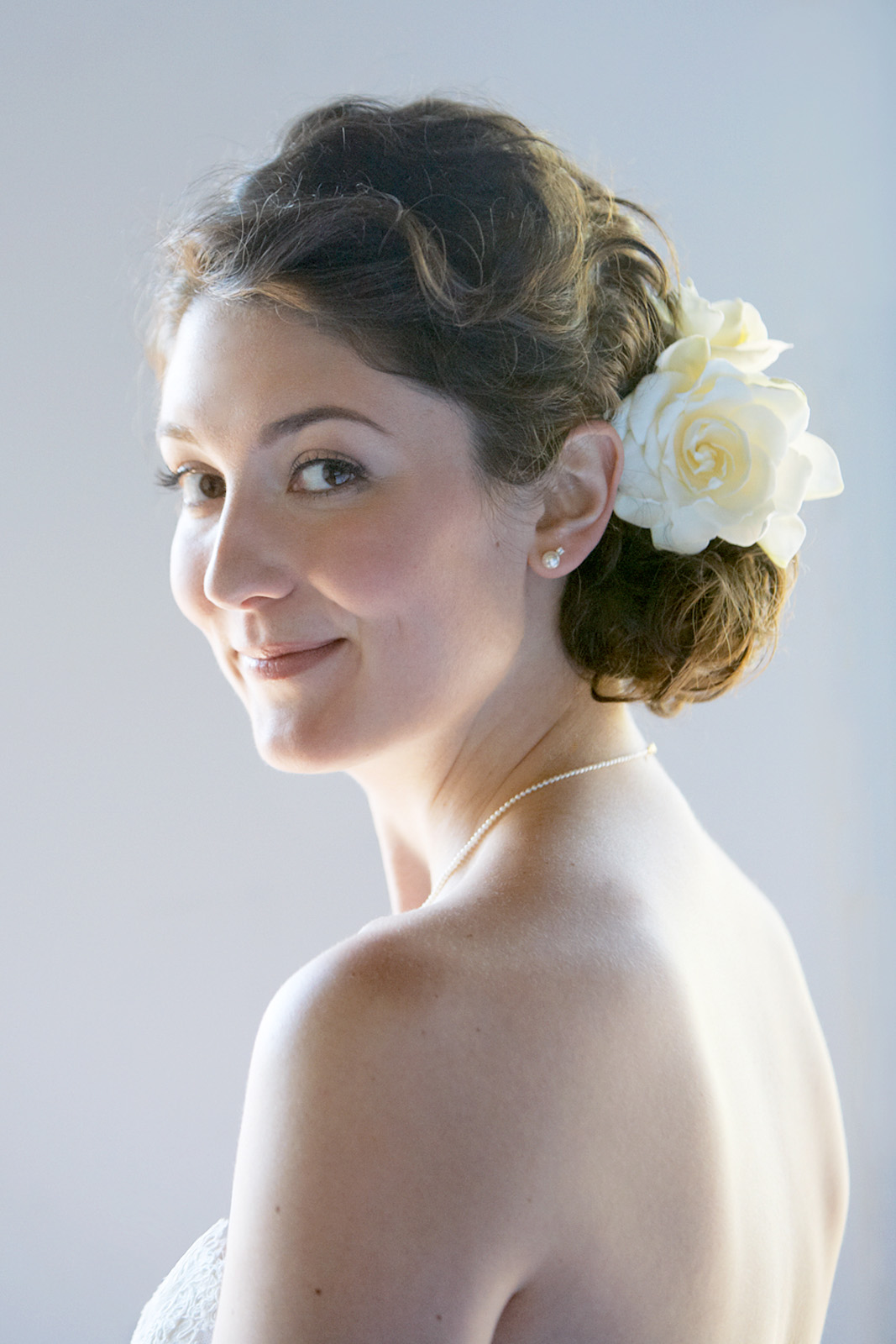 Close-up color head shot of bridal  portrait of a bride with a flower in her hair.