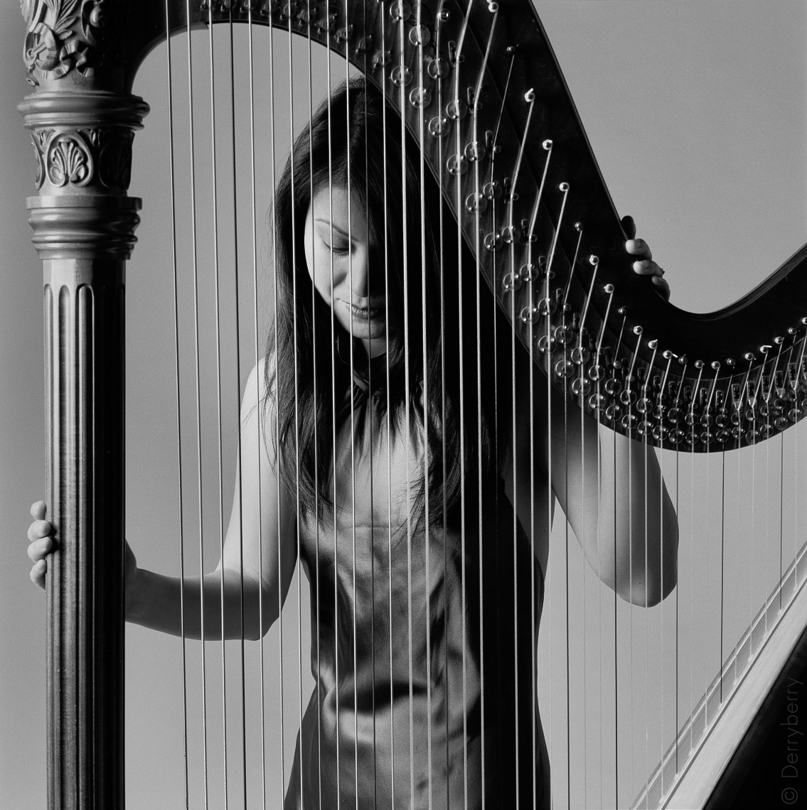 Portrait of harpist Naoko Stromberg in the studio with her harp in Dallas, Texas by photographer John Derryberry Photography