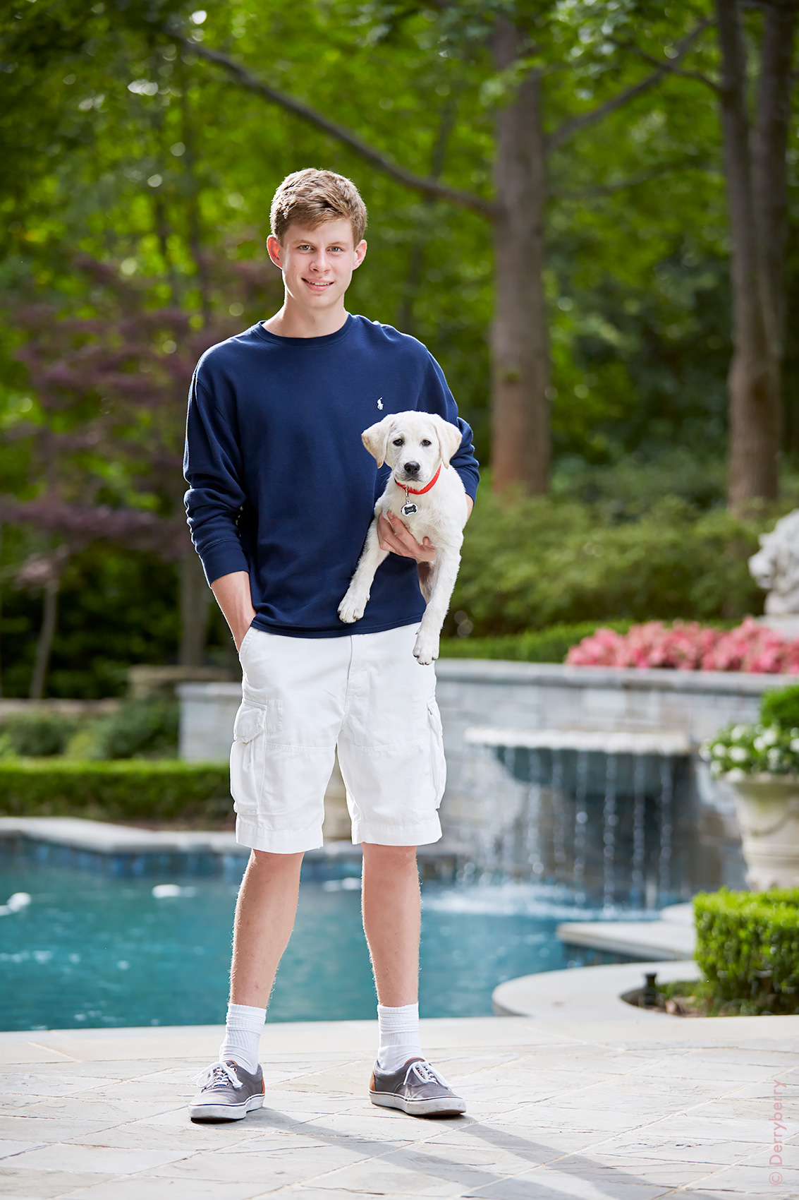 Color location portrait of Car Urschel and his Lab puppy in front of a swimming pool  in Dallas, Texas by photographer John Derryberry Photography