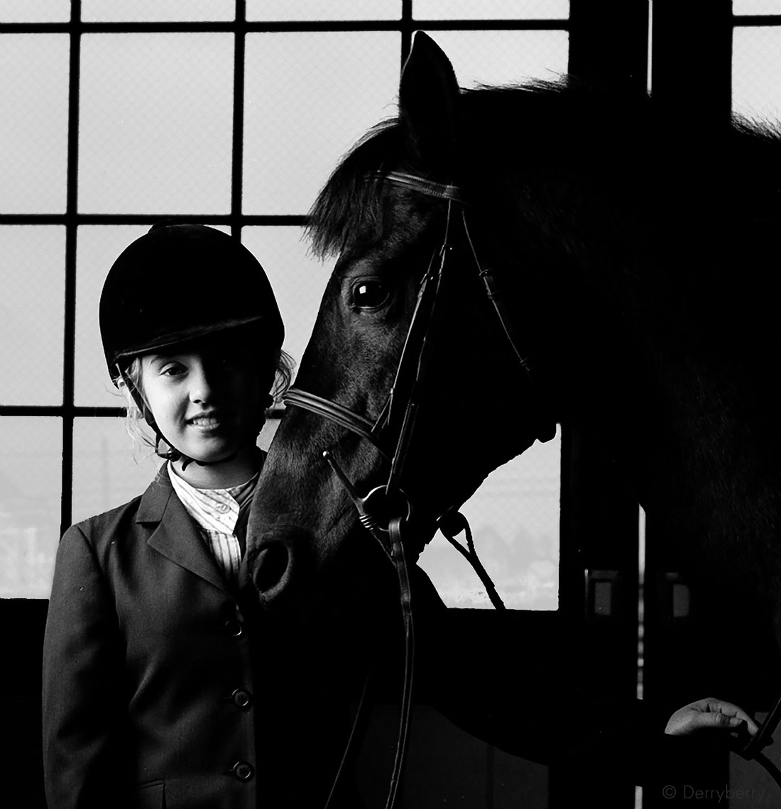 Black and white portrait of a girl and her horse in a barn in Lexington Kentucky by photographer John Derryberry Photography